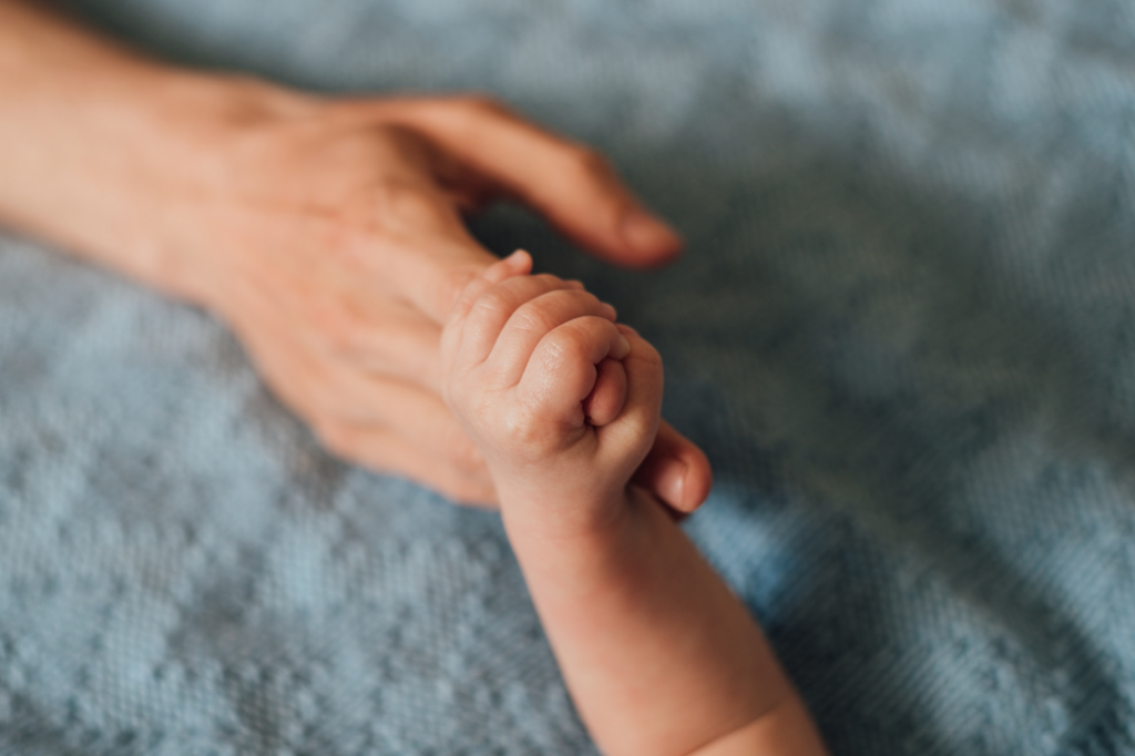 Picture of baby holding dad's hand